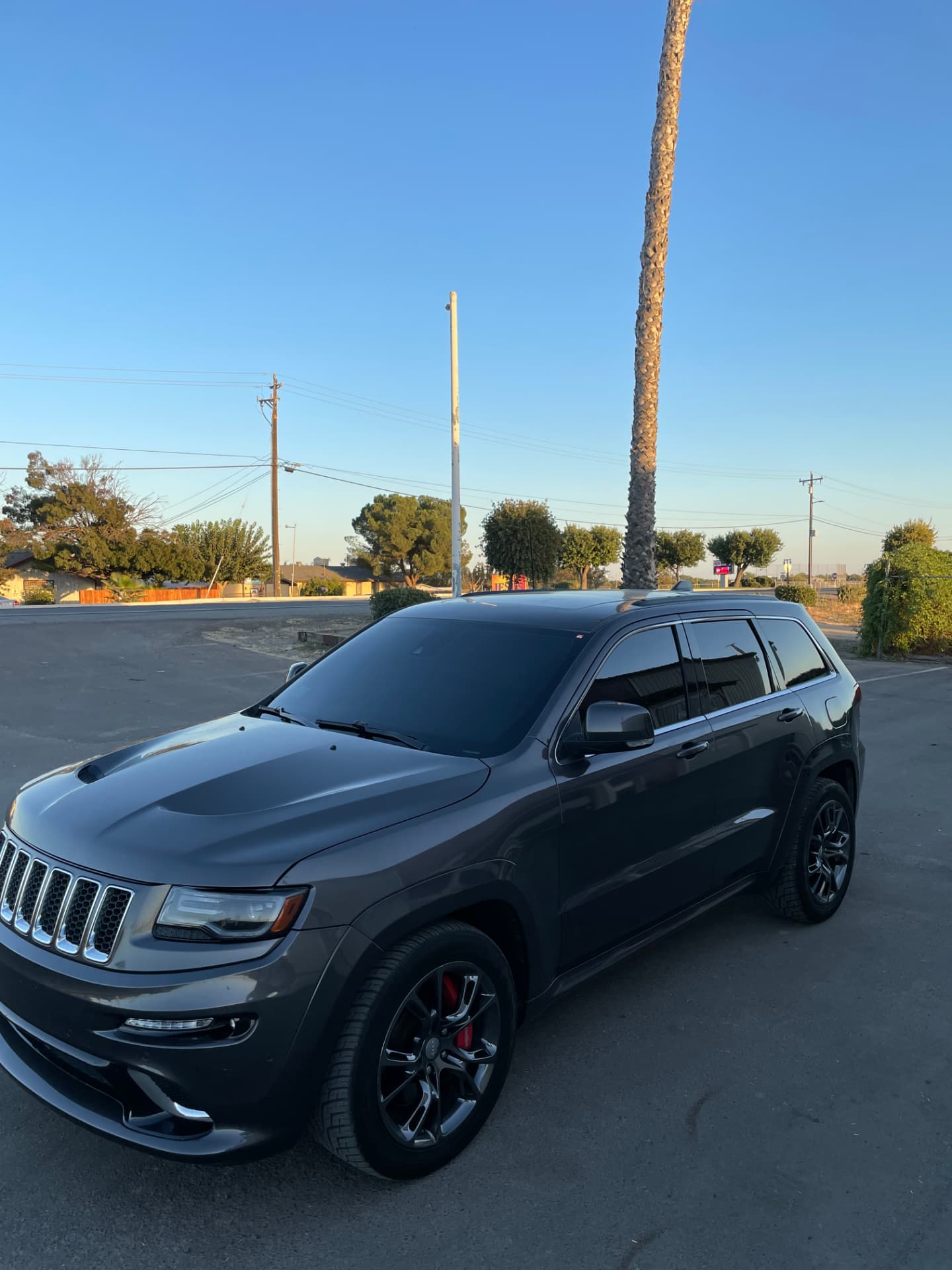 Grey Jeep Grand Cherokee SRT with tinted windows at sunset