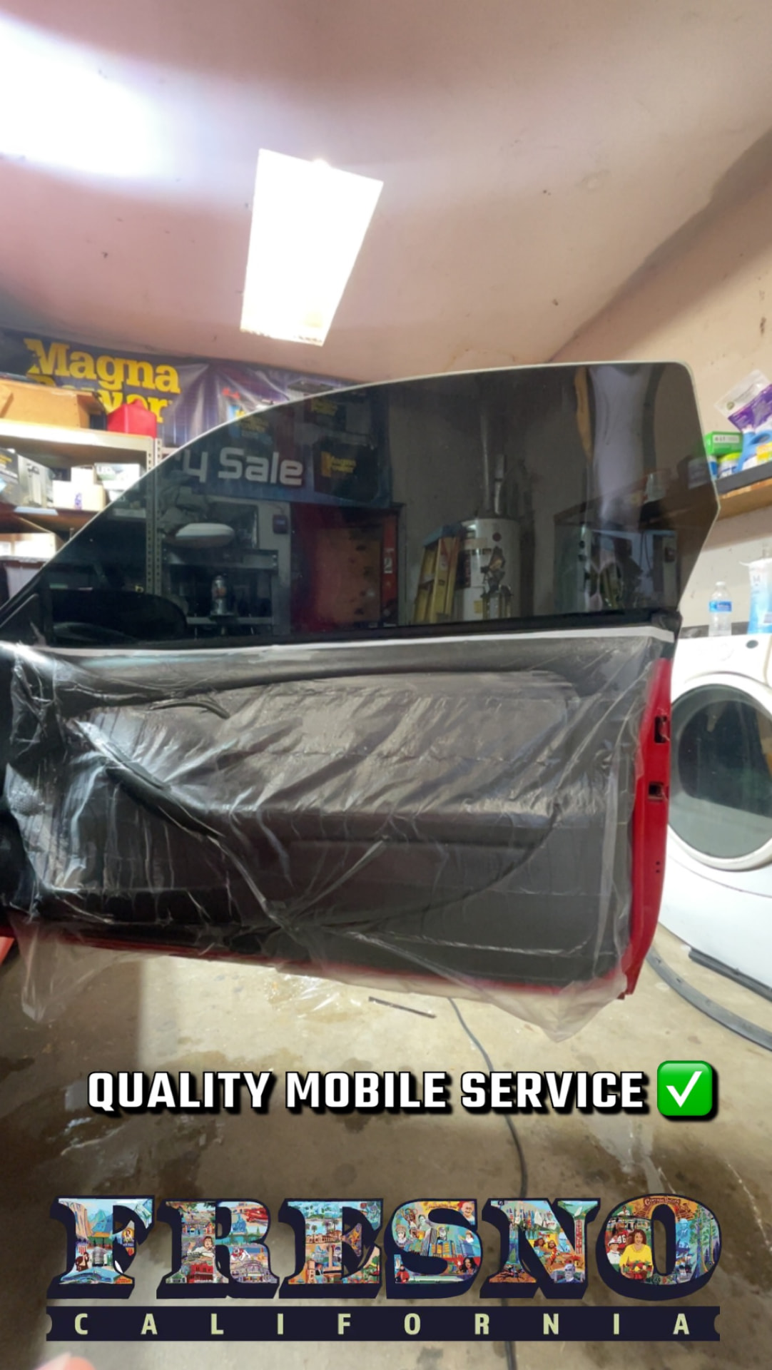 Vehicle door glass with newly installed window film during a mobile tinting appointment
