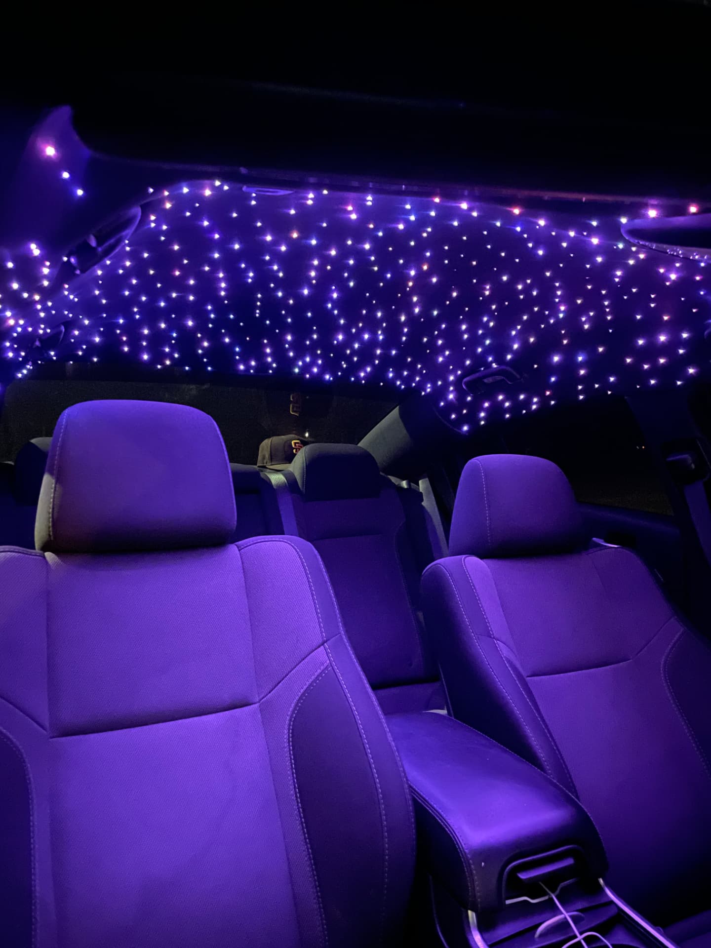 Custom fiber-optic starlight headliner glowing inside a vehicle